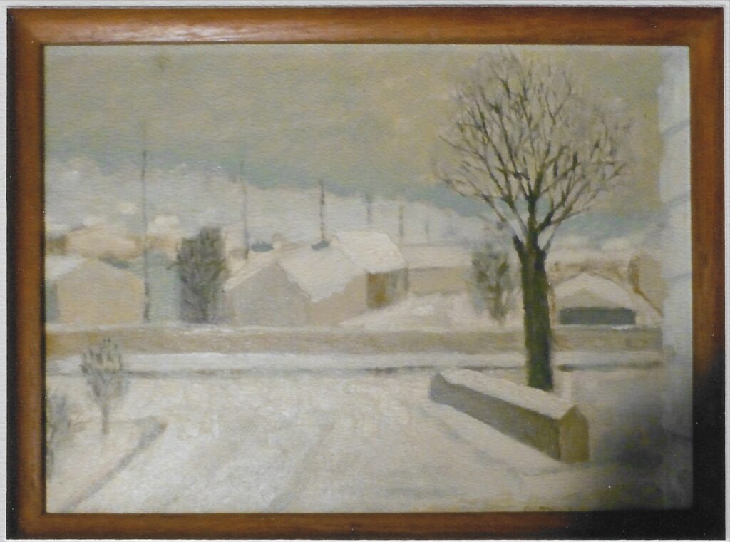 cour enneigée avec muret droit à droite et arbre nu derrière, maisons enneigées en arrière plan.