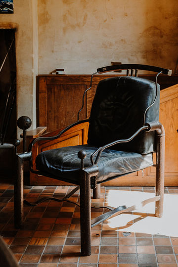 Grand fauteuil en acier avec garniture de cuir noir patiné, signé sur l'assise