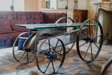 Table basse IPN en acier patiné sur roues en fer avec plateau en verre